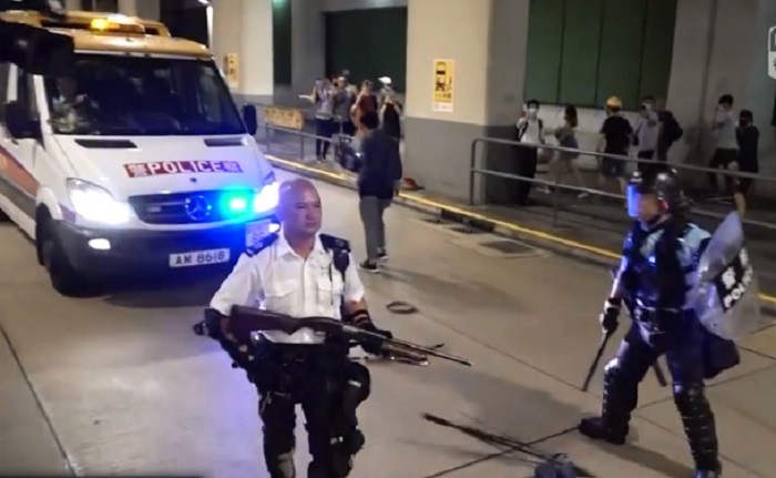 逾千港人30日晚間陸續前往葵涌警署抗議,部份示威者朝員警丟擲三角錐及雞蛋等物品,員警也發射胡椒噴霧還擊,並手持長槍指向人群。 圖:翻攝RTHK NEWS臉書影片 逾千港人30日晚間陸續前往葵涌警署抗議,部份示威者朝員警丟擲三角錐及雞蛋等物品,員警也發射胡椒噴霧還擊,並手持長槍指向人群。 圖:翻攝RTHK NEWS臉書影片