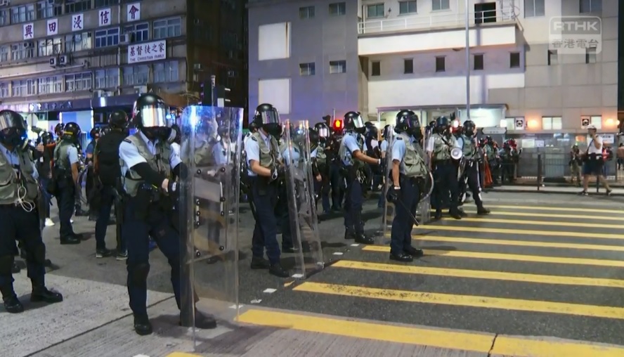 大批警力到場支援,手持盾牌、警棍向民眾步步進逼。 圖:翻攝香港電台臉書影片 大批警力到場支援,手持盾牌、警棍向民眾步步進逼。 圖:翻攝香港電台臉書影片
