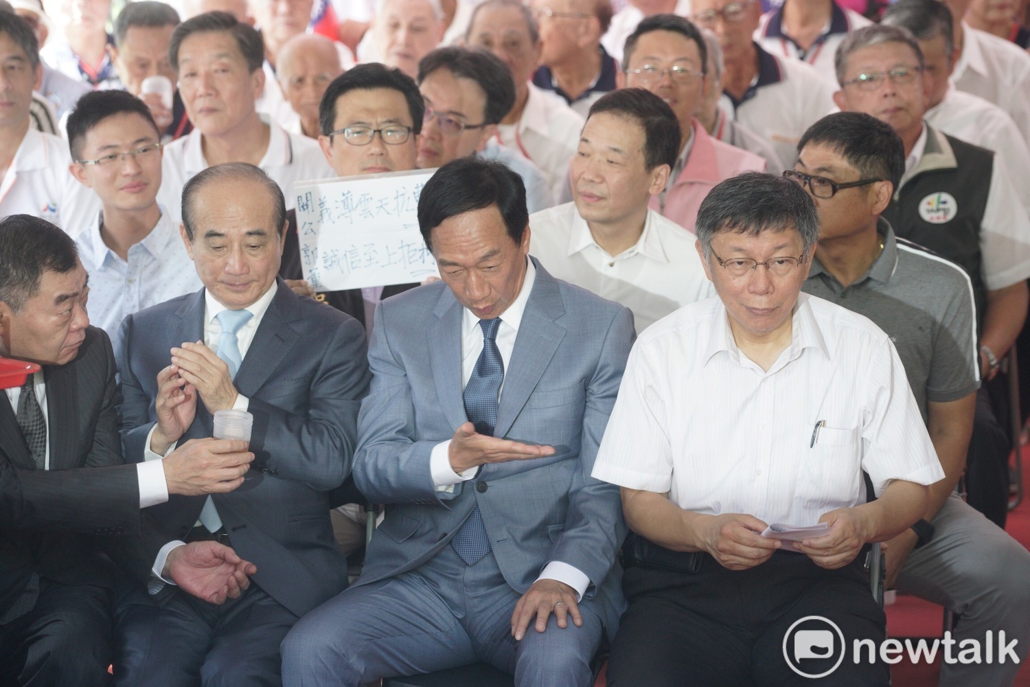 坐在郭、王、柯背後的國民黨議員吳世正高舉著「關公義薄雲天抗曹營,郭董誠信至上拒柯P」的標語,籲郭王拒絕和柯合作。 圖:張良一 / 攝 坐在郭、王、柯背後的國民黨議員吳世正高舉著「關公義薄雲天抗曹營,郭董誠信至上拒柯P」的標語,籲郭王拒絕和柯合作。 圖:張良一 / 攝