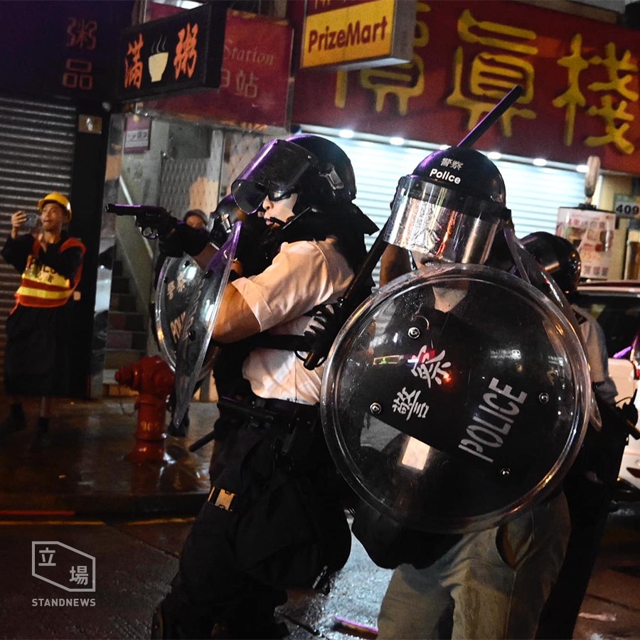 有香港警員拿槍對著人群和記者。 圖:擷取自立場新聞臉書。 有香港警員拿槍對著人群和記者。 圖:擷取自立場新聞臉書。