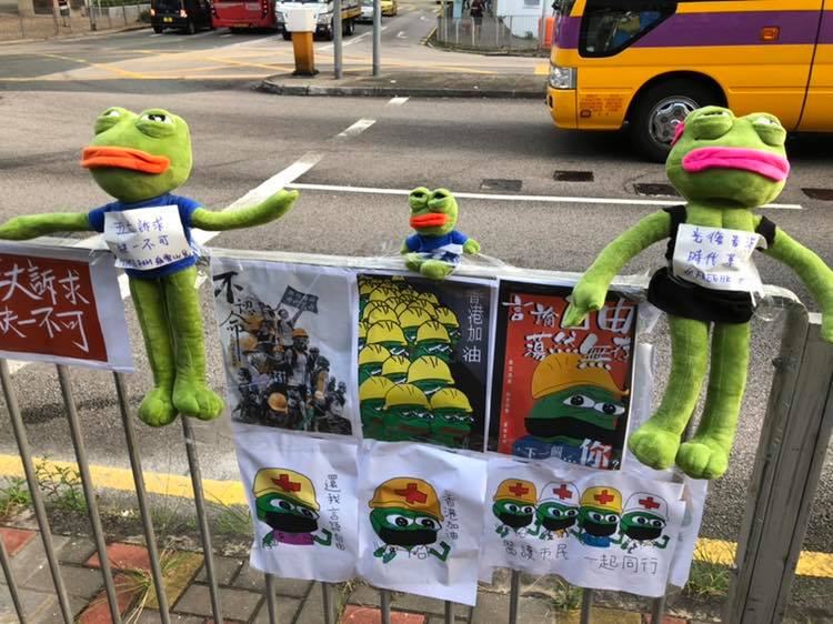 有中學生在人行道圍欄上以文宣海報與布偶做裝飾。 圖 : 翻攝自Stella Lam臉書 有中學生在人行道圍欄上以文宣海報與布偶做裝飾。 圖 : 翻攝自Stella Lam臉書