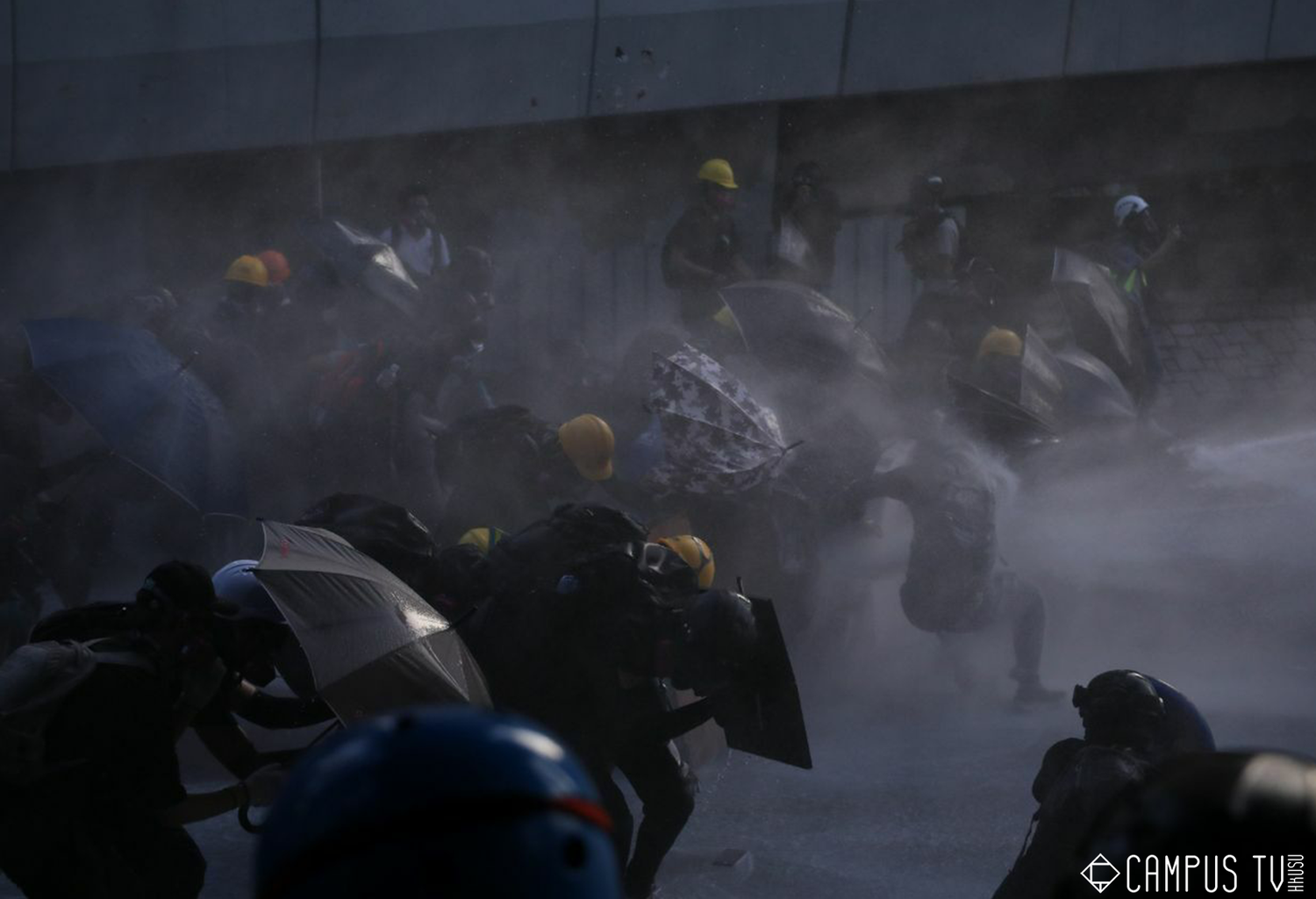 面對水砲車的攻擊,現場的港民只能趕緊開傘保護自己。 圖:翻攝自香港大學學生會校園電視臉書 面對水砲車的攻擊,現場的港民只能趕緊開傘保護自己。 圖:翻攝自香港大學學生會校園電視臉書