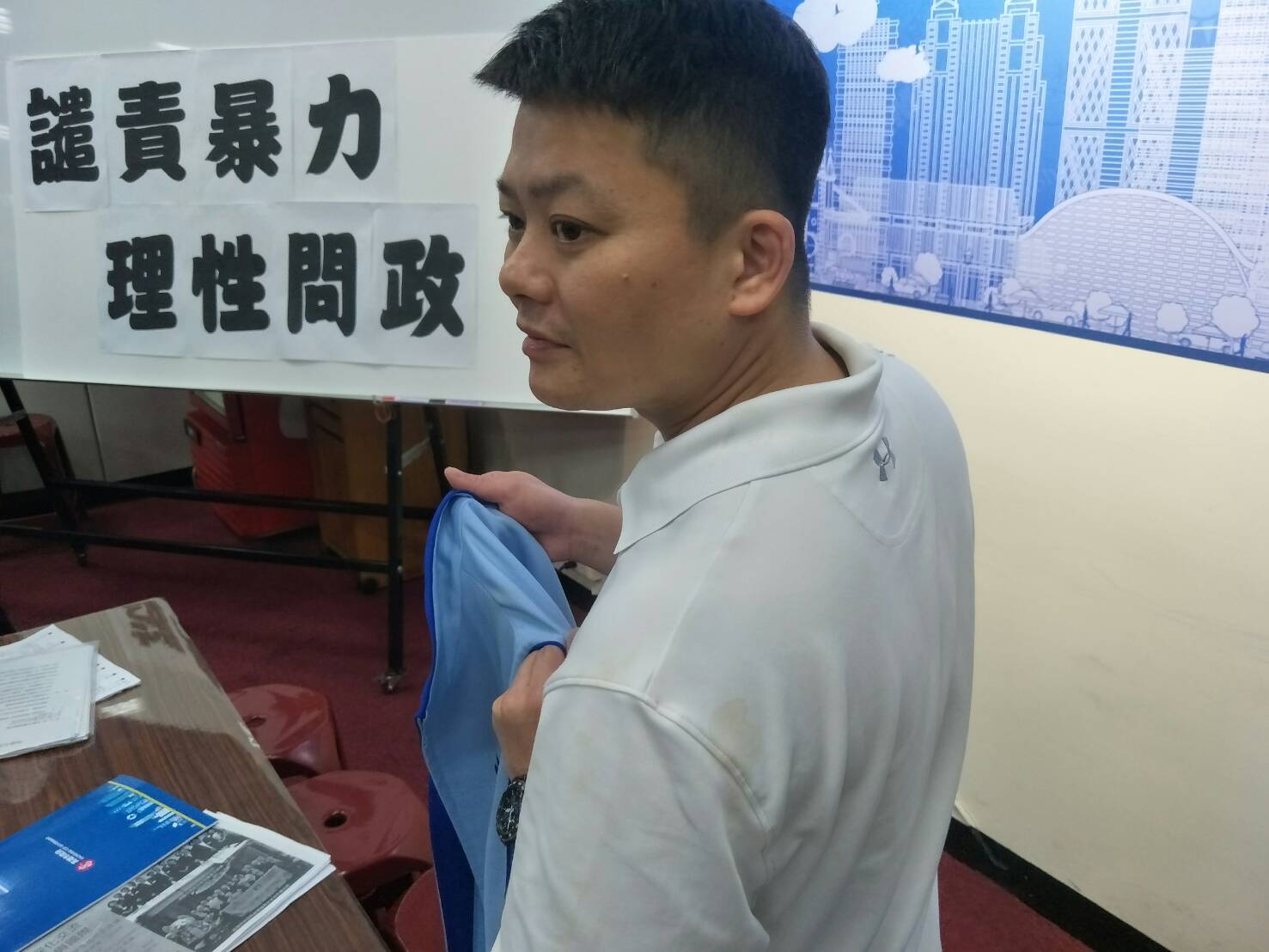 曾俊傑向媒體秀出染有咖啡漬的背心。 高雄市議會國民黨團 曾俊傑向媒體秀出染有咖啡漬的背心。 高雄市議會國民黨團