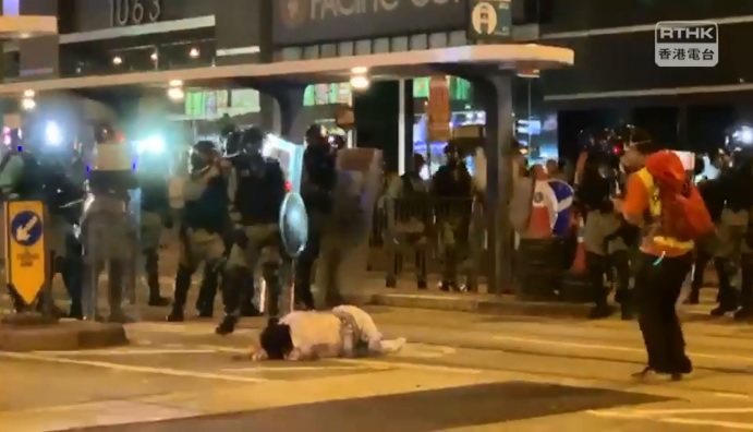 一名身穿類似和服的市民,站在警方防線前,被警員推跌地上。 圖:翻攝RTHK NEWS臉書影片 一名身穿類似和服的市民,站在警方防線前,被警員推跌地上。 圖:翻攝RTHK NEWS臉書影片
