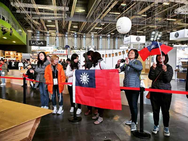 旅法台灣人在各群組傳遞比賽消息,動員前來。上午場館一開,就有許多台灣民眾手持國旗進場,並聚集於台灣隊工作檯前,為選手加油打氣。 圖:台灣麵包大使協會提供 旅法台灣人在各群組傳遞比賽消息,動員前來。上午場館一開,就有許多台灣民眾手持國旗進場,並聚集於台灣隊工作檯前,為選手加油打氣。 圖:台灣麵包大使協會提供