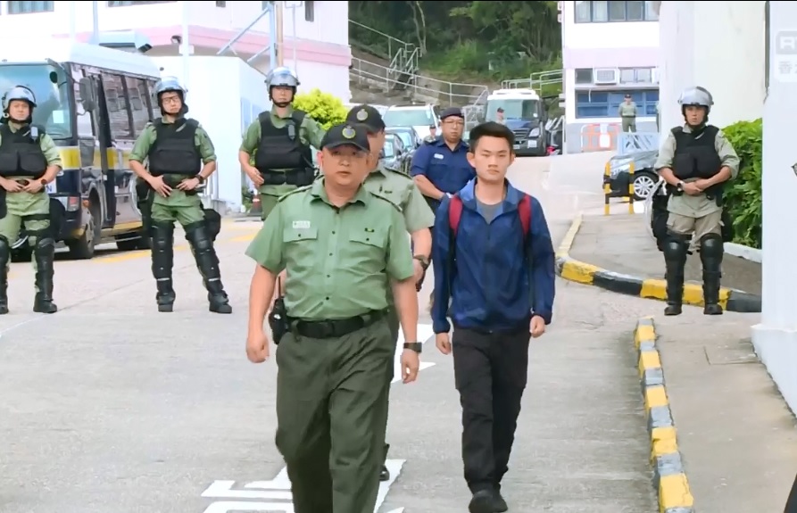 港人陳同佳(前排右)因為洗黑錢案遭判刑,23日上午9時許刑滿,步出壁屋監獄。 圖:翻攝自香港電台影像新聞臉書影片 港人陳同佳(前排右)因為洗黑錢案遭判刑,23日上午9時許刑滿,步出壁屋監獄。 圖:翻攝自香港電台影像新聞臉書影片
