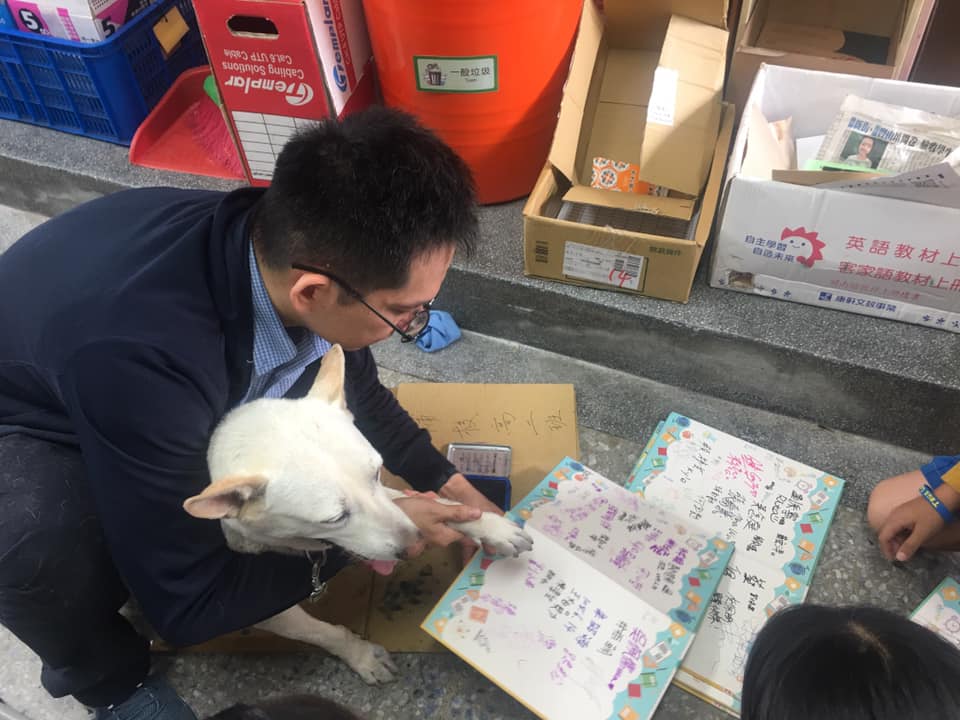 八里國小的校犬「黃玉枝」,忙著幫同學們蓋畢業紀念冊。 圖:新北市動保處/提供 八里國小的校犬「黃玉枝」,忙著幫同學們蓋畢業紀念冊。 圖:新北市動保處/提供