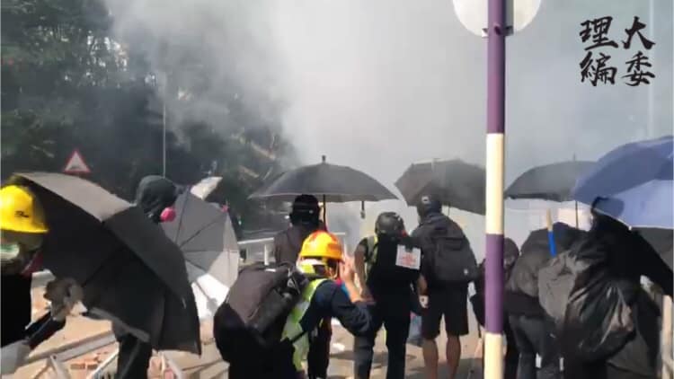 中大校園彷彿成戰場,學生以雨傘抵擋警方催淚彈。 圖:翻攝自理大學生報編委 中大校園彷彿成戰場,學生以雨傘抵擋警方催淚彈。 圖:翻攝自理大學生報編委