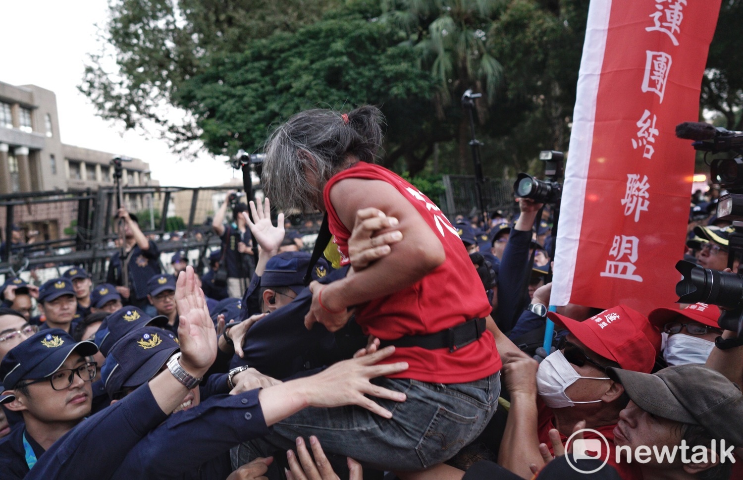一名紅衣男子試圖越過拒馬、進入行政院,遭警方攔阻。 圖:張良一/攝 一名紅衣男子試圖越過拒馬、進入行政院,遭警方攔阻。 圖:張良一/攝
