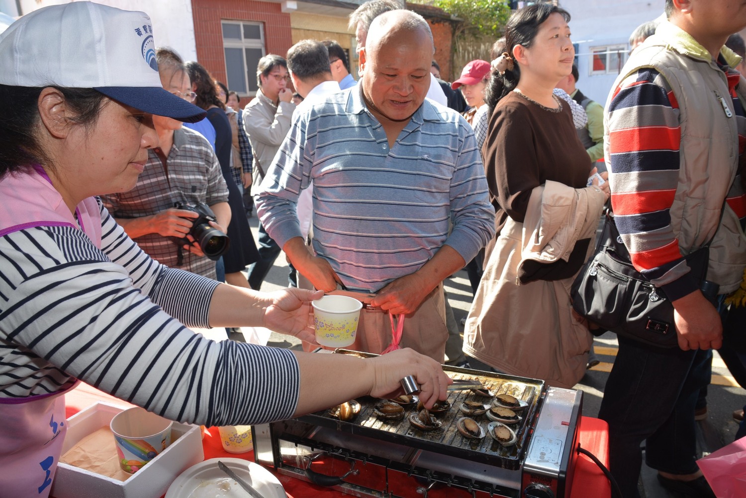 民眾到澳底漁港參加新北貢寮鮑產地活動,品嘗烤鮮鮑。 圖:新北市漁管處提供 民眾到澳底漁港參加新北貢寮鮑產地活動,品嘗烤鮮鮑。 圖:新北市漁管處提供