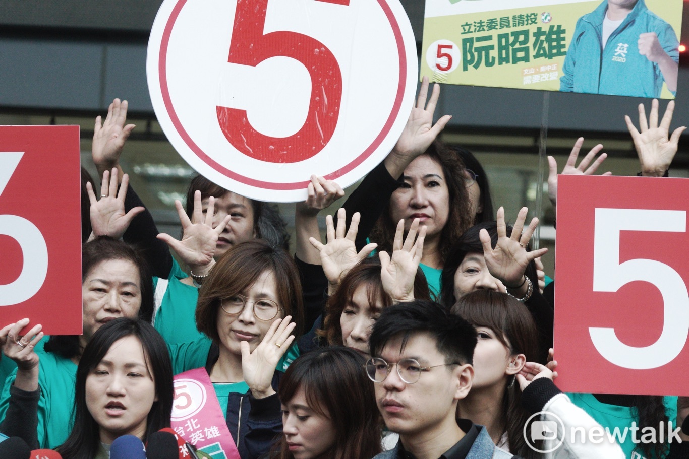 民進黨立委候選人的工作人員用手勢比出立委候選人的號次。 圖:張良一/攝 民進黨立委候選人的工作人員用手勢比出立委候選人的號次。 圖:張良一/攝
