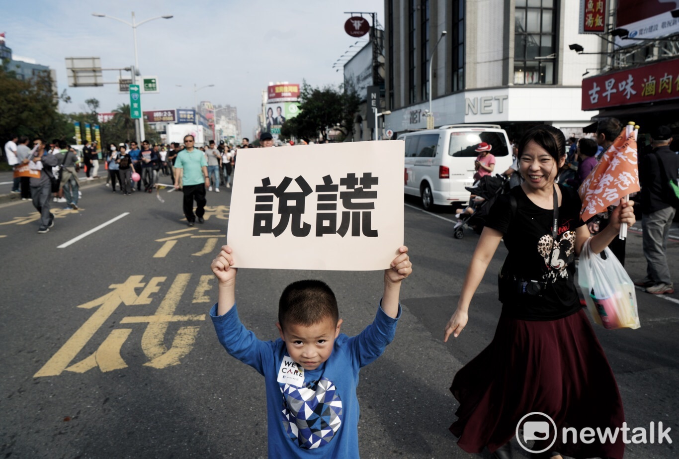 年幼孩童高舉大幅的「說謊」看板,兩者形成強烈對比。 圖:張良一/攝 年幼孩童高舉大幅的「說謊」看板,兩者形成強烈對比。 圖:張良一/攝