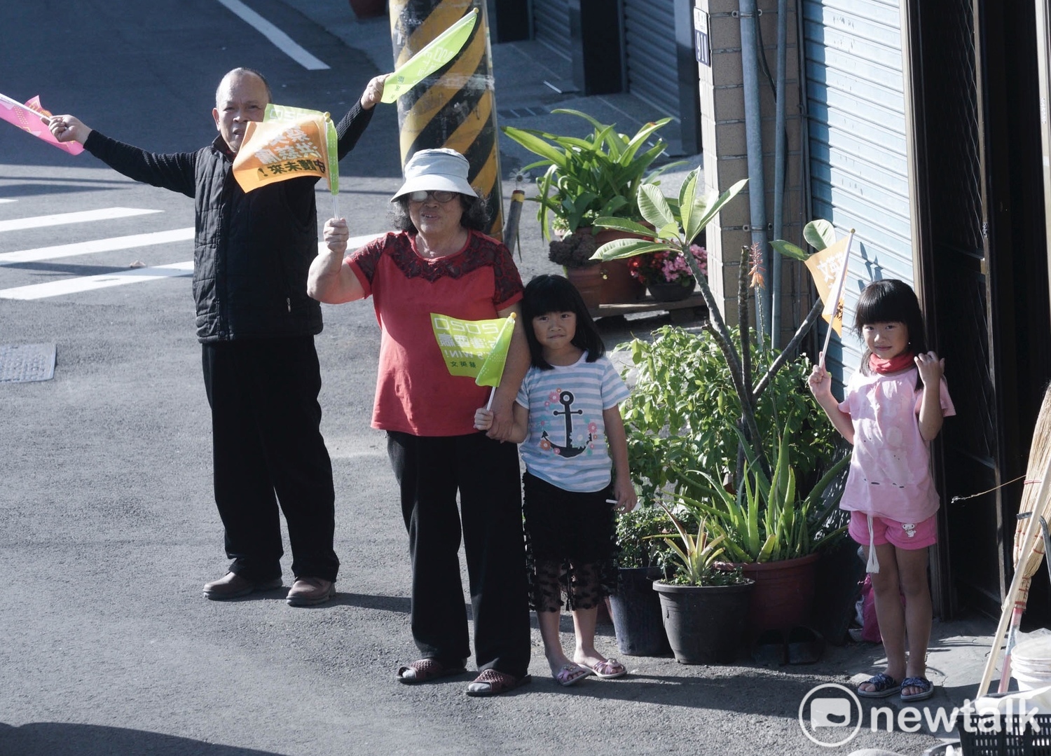 一位阿嬤帶著兩位小孫女在家門口等待小英掃街車隊到來。 圖:張良一/攝 一位阿嬤帶著兩位小孫女在家門口等待小英掃街車隊到來。 圖:張良一/攝