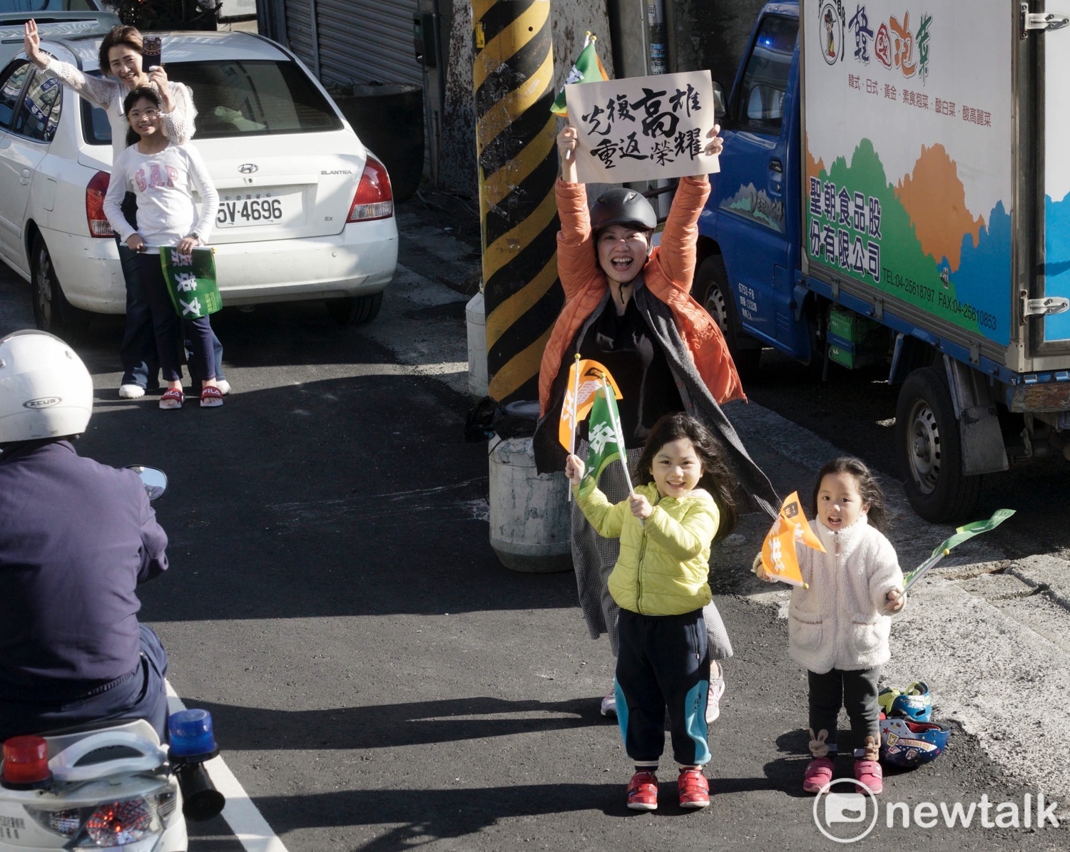 一位媽媽在台中神岡帶著兩位女兒為小英加油,她高舉「光復高雄重返榮耀」手舉牌。 圖:張良一/攝 一位媽媽在台中神岡帶著兩位女兒為小英加油,她高舉「光復高雄重返榮耀」手舉牌。 圖:張良一/攝