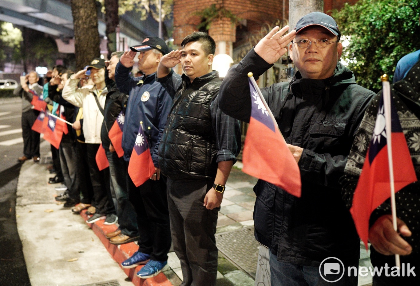 多位民眾帶著小國旗在殉職將士靈柩經過的路旁,向殉職忠靈敬禮致敬。 圖:張良一/攝 多位民眾帶著小國旗在殉職將士靈柩經過的路旁,向殉職忠靈敬禮致敬。 圖:張良一/攝