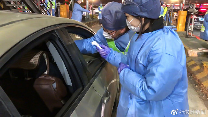 志願者對入滬車輛的司機、乘客進行體溫量測。 圖:翻攝澎湃新聞 志願者對入滬車輛的司機、乘客進行體溫量測。 圖:翻攝澎湃新聞