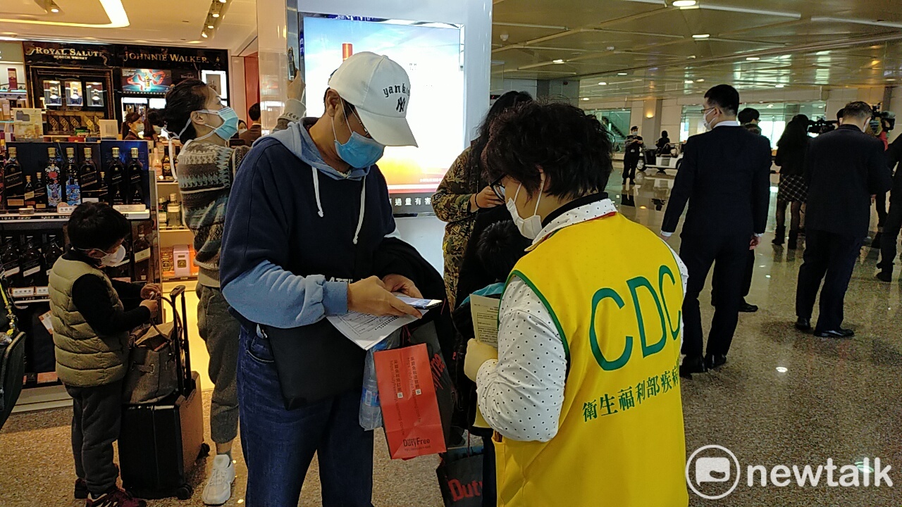 防疫人員在機場向入境旅客說明檢疫流程。 圖:林昀真/攝(資料照片) 防疫人員在機場向入境旅客說明檢疫流程。 圖:林昀真/攝(資料照片)