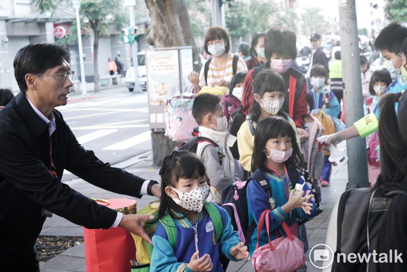 北市新和國小校長張伯謙引導小朋友們進校園量測額溫。 圖:張良一/攝 北市新和國小校長張伯謙引導小朋友們進校園量測額溫。 圖:張良一/攝
