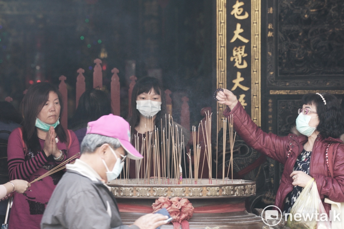 民眾戴著口罩在板橋慈惠宮上香。 圖:張良一/攝 民眾戴著口罩在板橋慈惠宮上香。 圖:張良一/攝