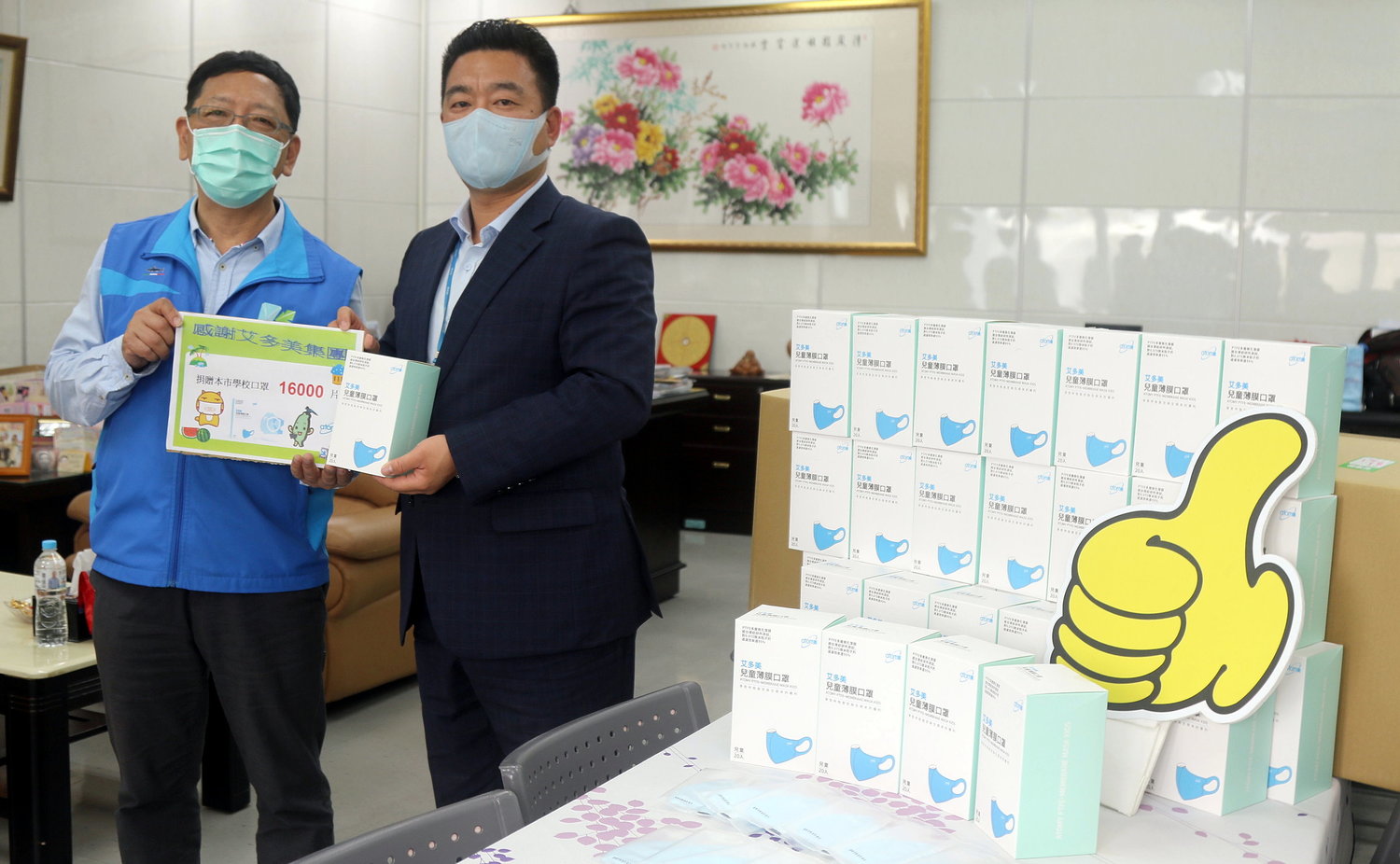 吳榕峯(左)接受艾多美公司捐贈的兒童口罩。 圖:高雄市教育局/提供 吳榕峯(左)接受艾多美公司捐贈的兒童口罩。 圖:高雄市教育局/提供