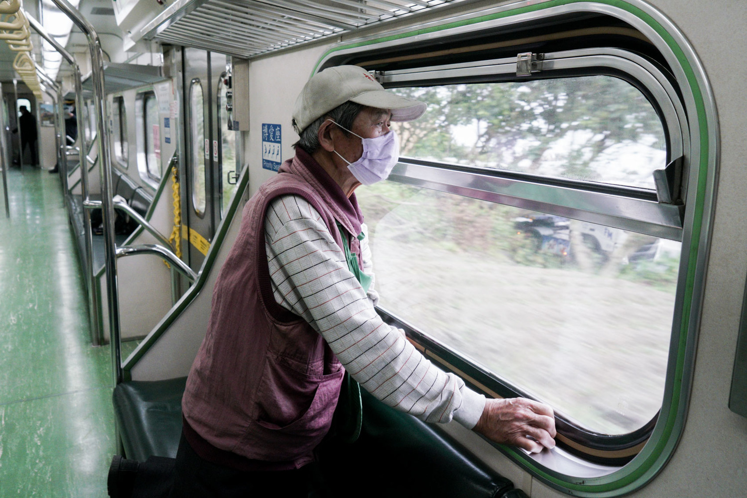 一位阿伯在火車上凝視著窗外風景。 圖:張良一/攝 一位阿伯在火車上凝視著窗外風景。 圖:張良一/攝