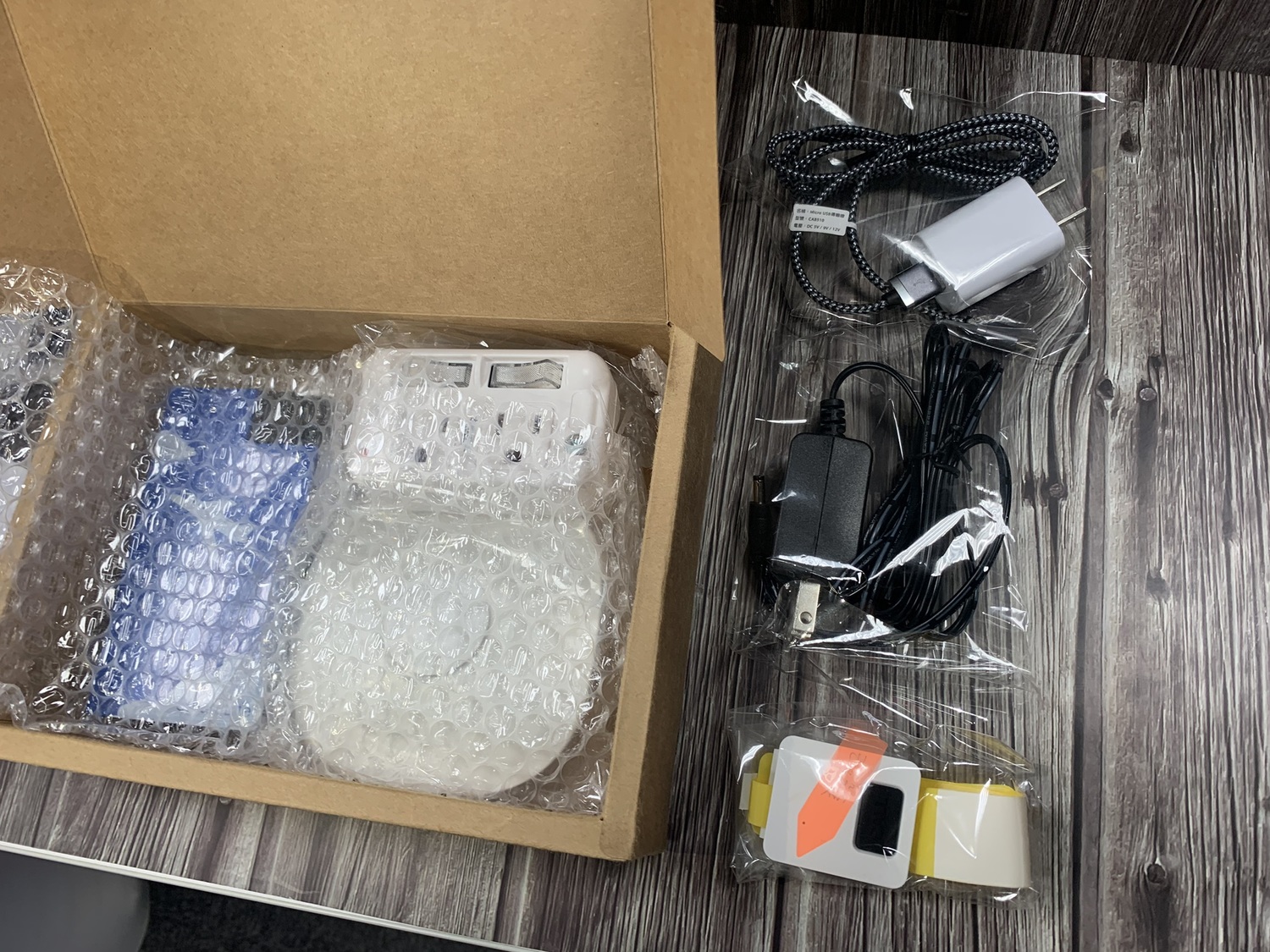 智慧離家警報器(盒內白色圓形)與闔家守護環(右前)設備陳列。 圖/黃耀寬提供 智慧離家警報器(盒內白色圓形)與闔家守護環(右前)設備陳列。 圖/黃耀寬提供