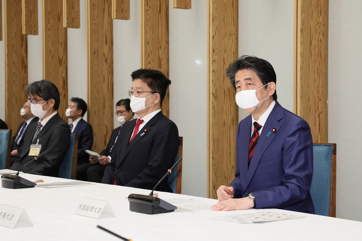 日本首相安倍晉三(右)22日出席記者會,戴的口罩尺寸明顯不合,只能勉強棄住口鼻。 圖:翻攝自日本首相官邸 日本首相安倍晉三(右)22日出席記者會,戴的口罩尺寸明顯不合,只能勉強棄住口鼻。 圖:翻攝自日本首相官邸