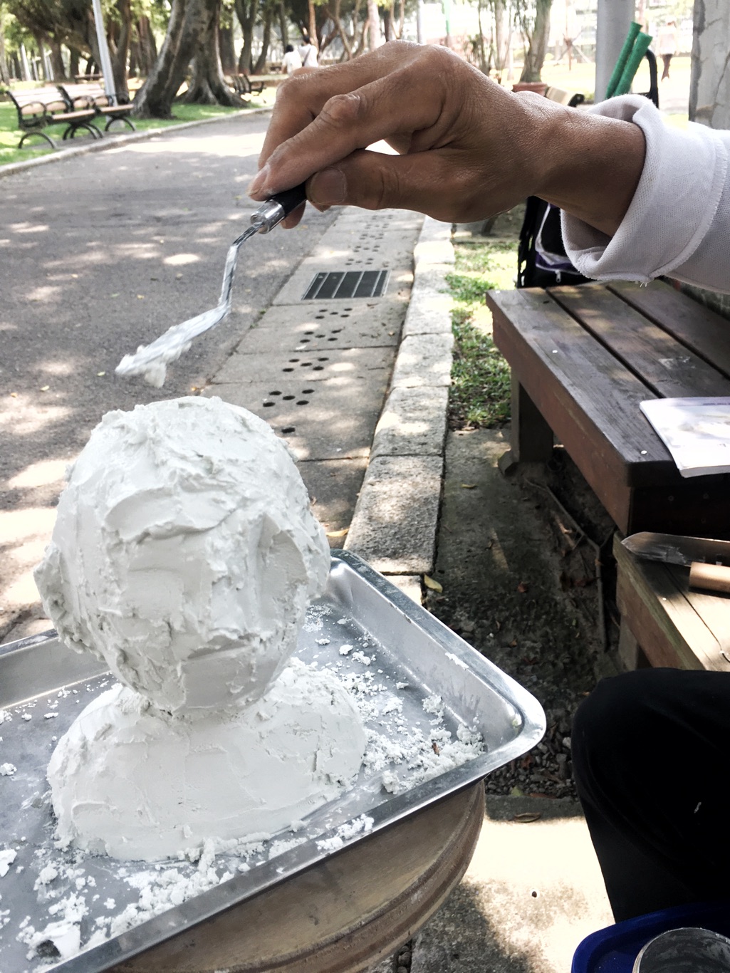 趙再添用白色水泥一刀一刀刻畫他所欣賞的人物。他正在為鴻海創辦人郭台銘雕塑頭像。 圖:張良一/攝 趙再添用白色水泥一刀一刀刻畫他所欣賞的人物。他正在為鴻海創辦人郭台銘雕塑頭像。 圖:張良一/攝