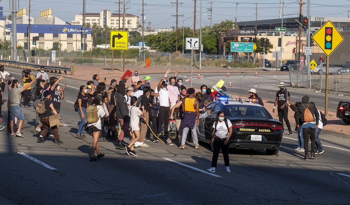 美國各地非裔族群在洛杉磯公路上抗議,並且包圍警車。 圖:達志影像/美聯社 美國各地非裔族群在洛杉磯公路上抗議,並且包圍警車。 圖:達志影像/美聯社