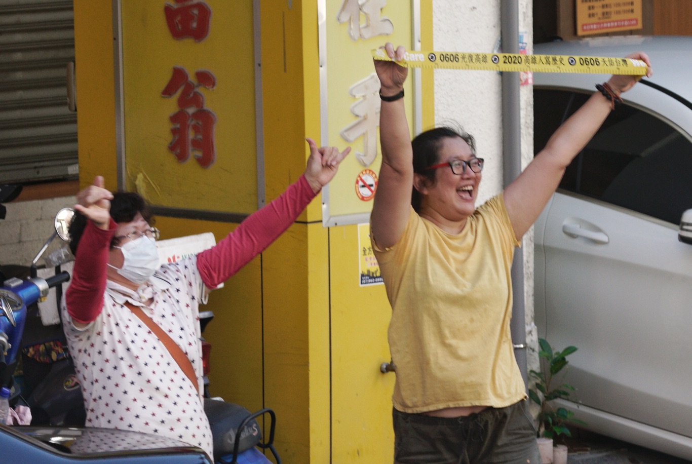 兩位市民,一位比出象徵罷韓的六號手勢,一位高舉罷韓黃絲帶向掃街車隊上的人員加油打氣。 圖:張良一/攝 兩位市民,一位比出象徵罷韓的六號手勢,一位高舉罷韓黃絲帶向掃街車隊上的人員加油打氣。 圖:張良一/攝