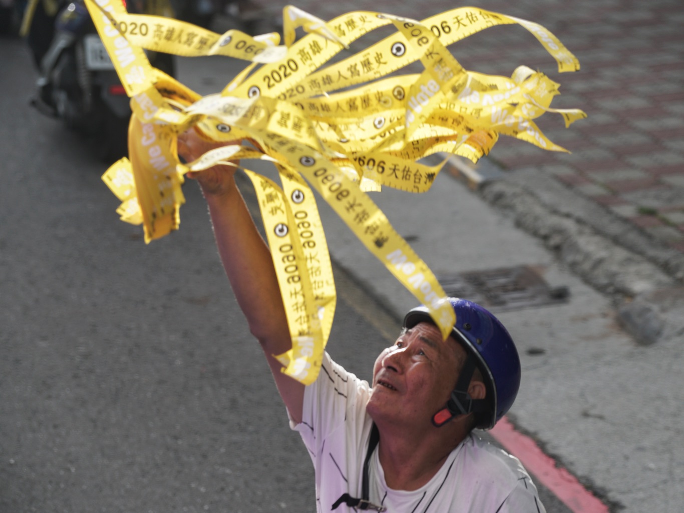 一位市民接到車隊上的工作人員發放的民主黃絲帶。 圖:張良一/攝 一位市民接到車隊上的工作人員發放的民主黃絲帶。 圖:張良一/攝