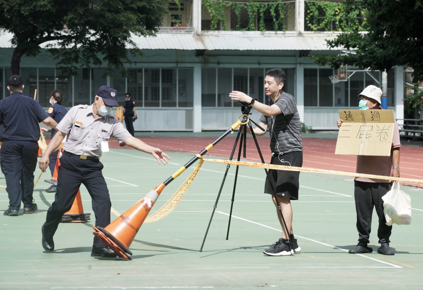 選務人員原先架設的警戒線離投票所僅15公尺,經重新測量後,將進行錄影的民眾勸離到30公尺外。 圖:張良一/攝 選務人員原先架設的警戒線離投票所僅15公尺,經重新測量後,將進行錄影的民眾勸離到30公尺外。 圖:張良一/攝