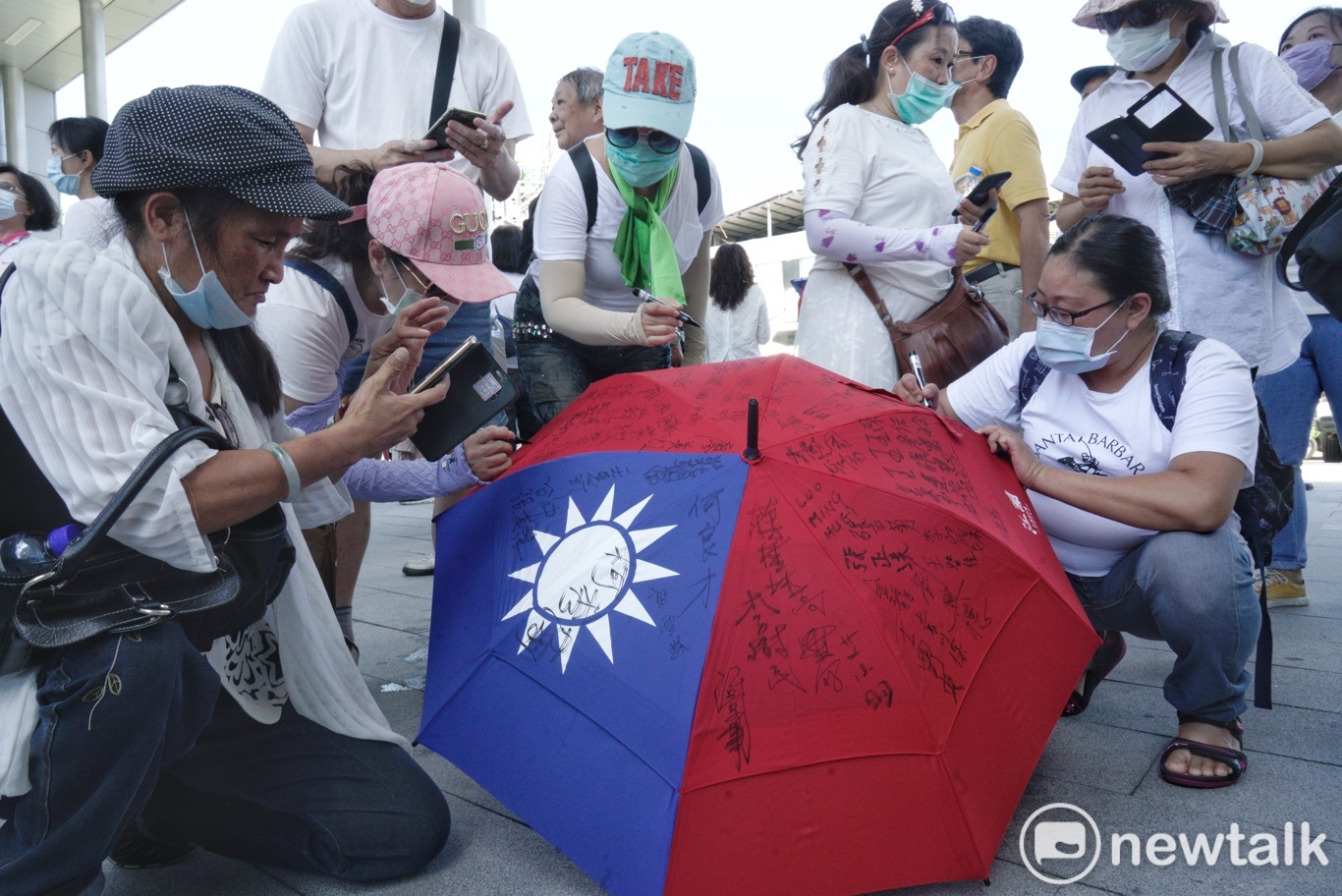韓粉在國旗傘上簽名。 圖:張良一/攝 韓粉在國旗傘上簽名。 圖:張良一/攝