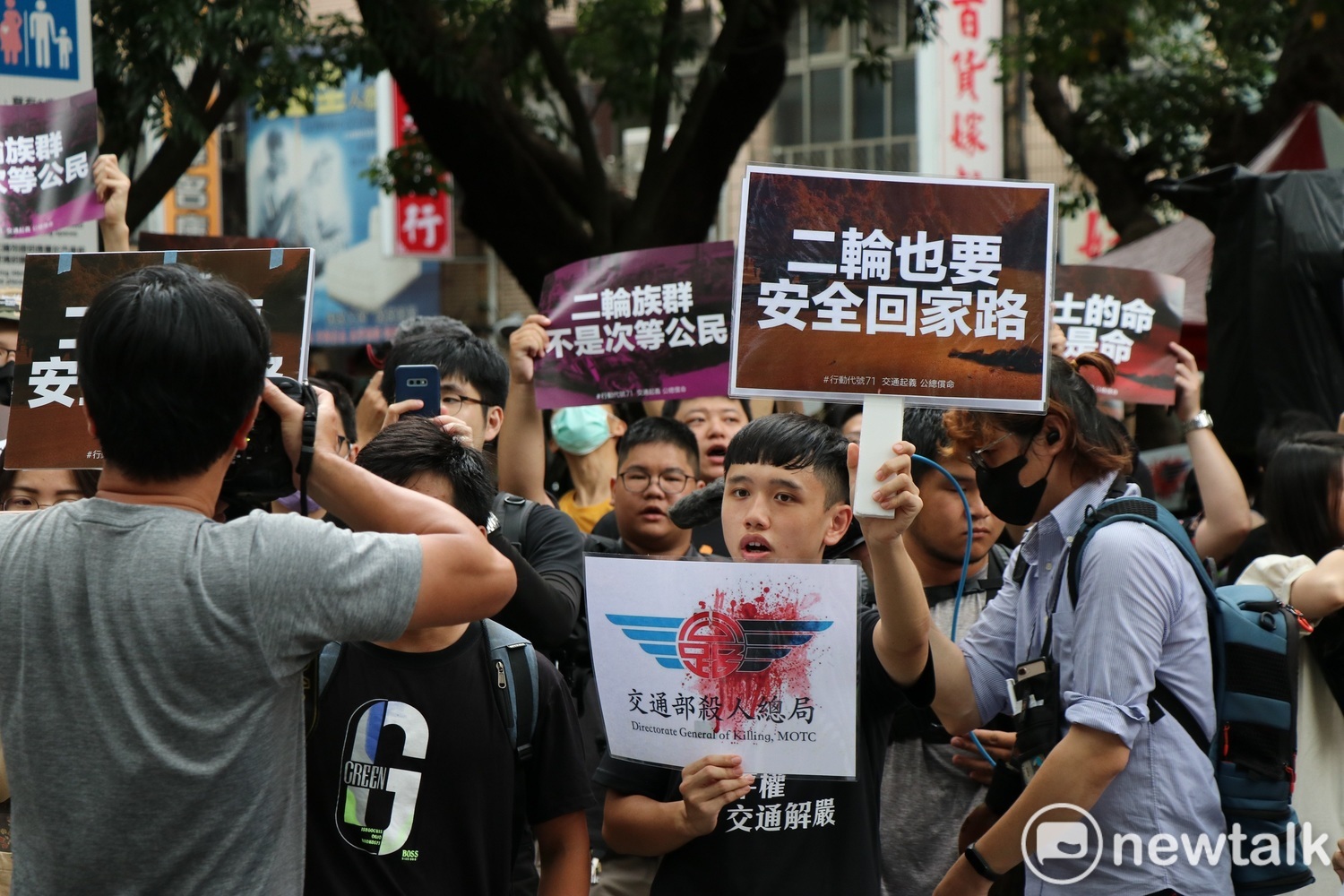 抗議群眾手持「二輪也要安全回家路」,要求交通部開放道路共享。 圖:謝孟華/攝 抗議群眾手持「二輪也要安全回家路」,要求交通部開放道路共享。 圖:謝孟華/攝