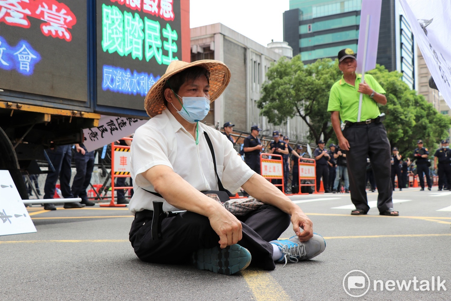 北上抗議農民,帶著斗笠坐在滾燙的柏油路上,無聲抗議立法院蠻橫通過水利會改為公務機關剝奪農民財產。 圖:謝孟華/攝 北上抗議農民,帶著斗笠坐在滾燙的柏油路上,無聲抗議立法院蠻橫通過水利會改為公務機關剝奪農民財產。 圖:謝孟華/攝