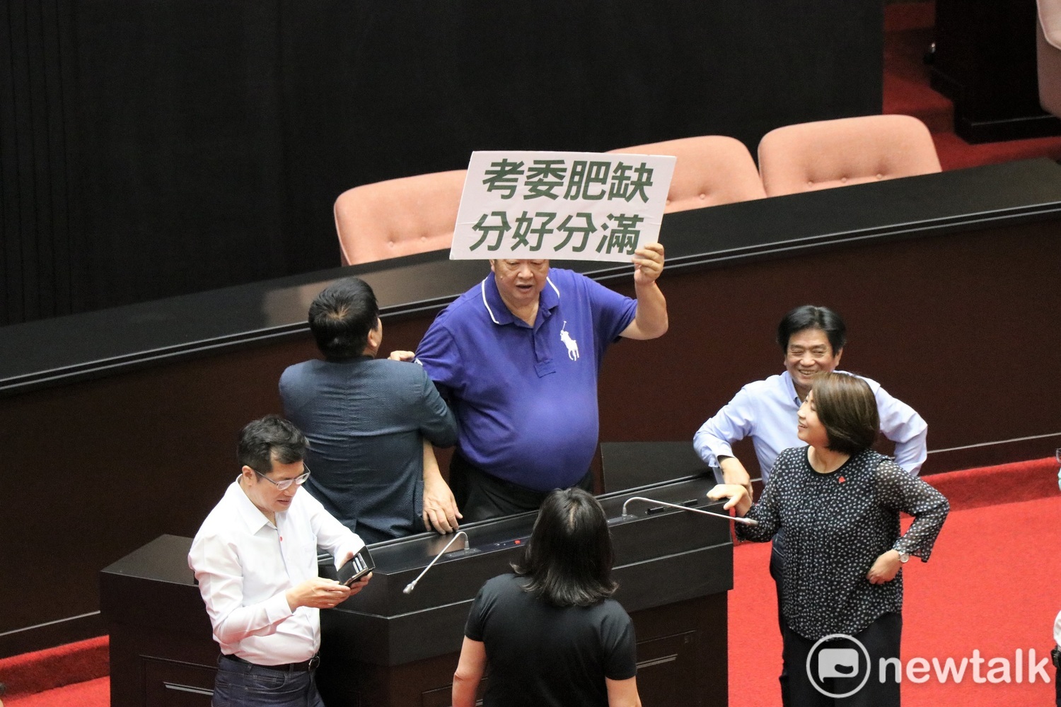 國民黨立委陳雪生(圖中舉牌男)遭范雲指控,今天上午在議場用肚子多次頂了她的背。 圖:謝孟華/攝(資料照片) 國民黨立委陳雪生(圖中舉牌男)遭范雲指控,今天上午在議場用肚子多次頂了她的背。 圖:謝孟華/攝(資料照片)
