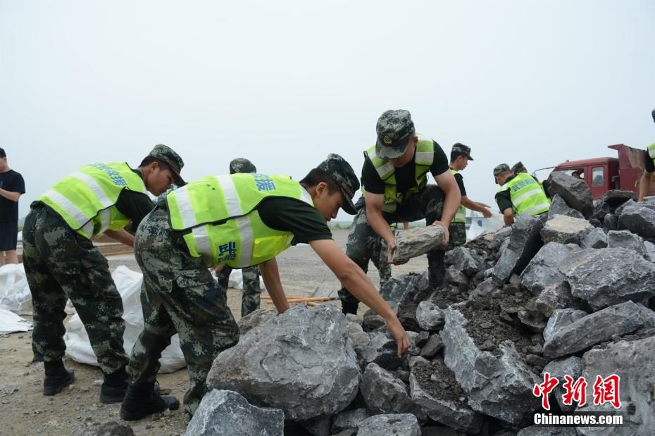 中國洪災湖北陽新出現潰堤,武警搬動石塊堵住缺口。 圖 : 翻攝自中新網 中國洪災湖北陽新出現潰堤,武警搬動石塊堵住缺口。 圖 : 翻攝自中新網