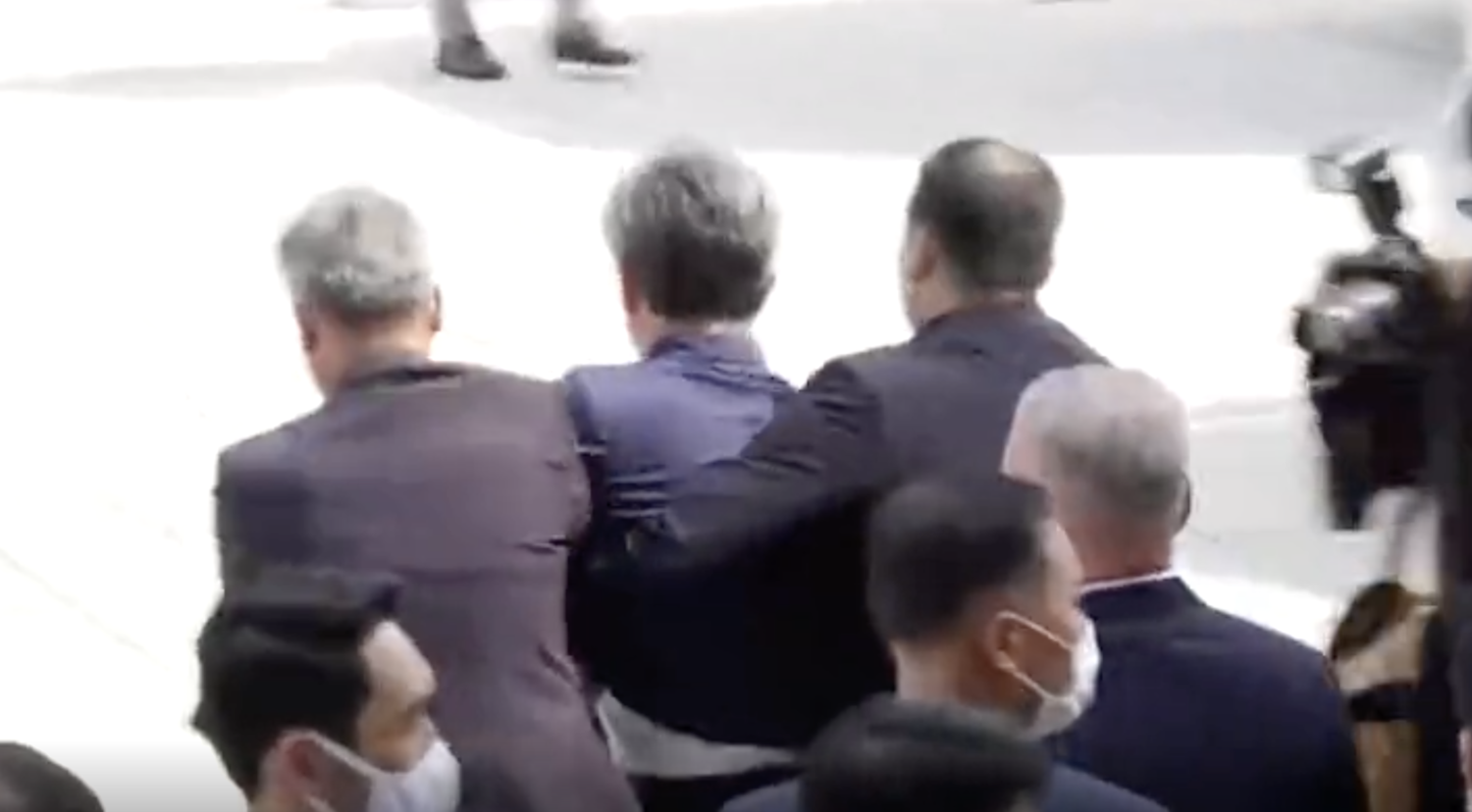 向文在寅丟鞋的抗議者被警方迅速架離現場。 圖:擷取自環球網 向文在寅丟鞋的抗議者被警方迅速架離現場。 圖:擷取自環球網