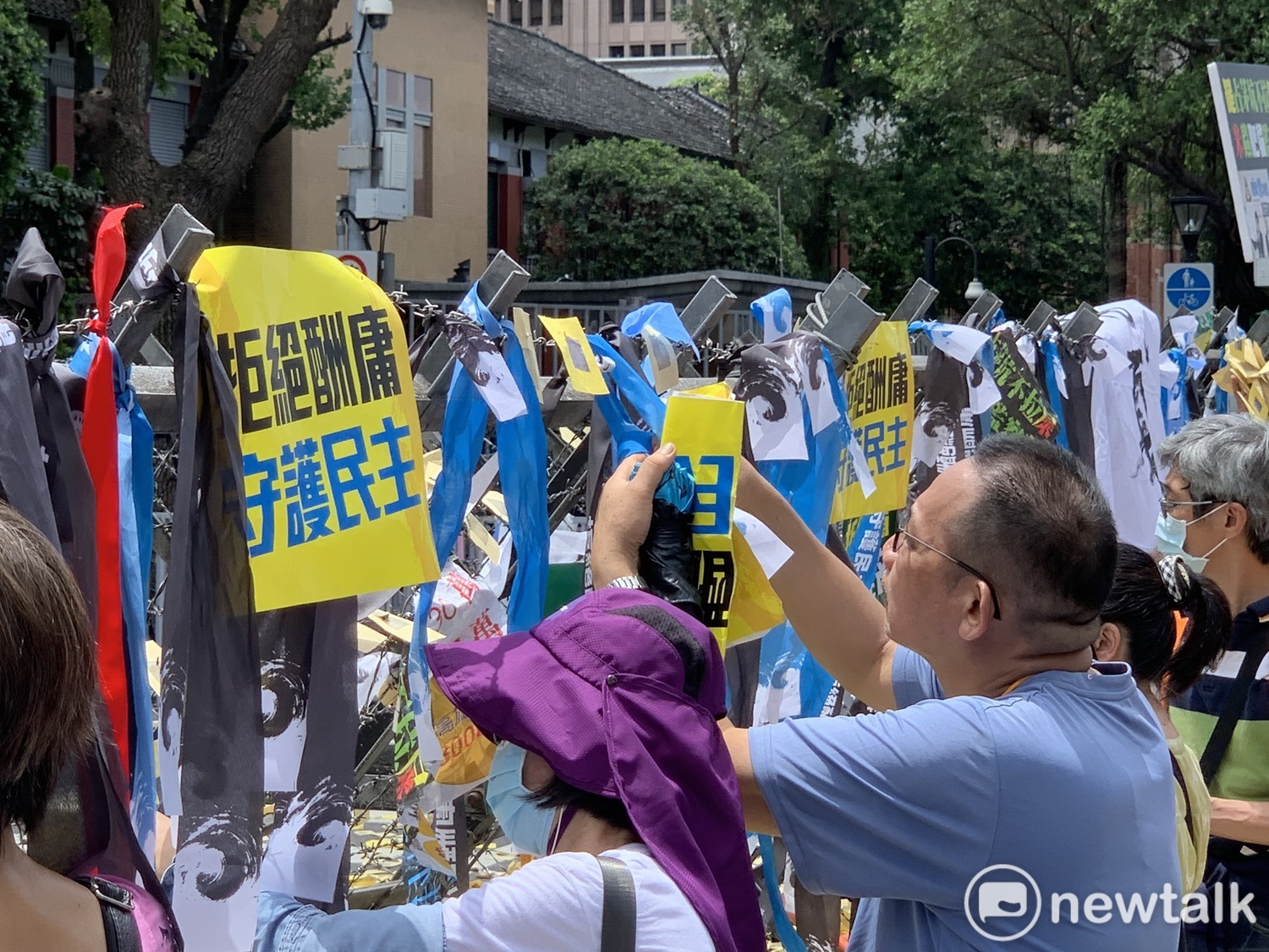 國民黨支持者在拒馬上掛上「拒絕酬庸,守護民主」的紙卡與緞帶。 圖:羅國嘉/攝 國民黨支持者在拒馬上掛上「拒絕酬庸,守護民主」的紙卡與緞帶。 圖:羅國嘉/攝