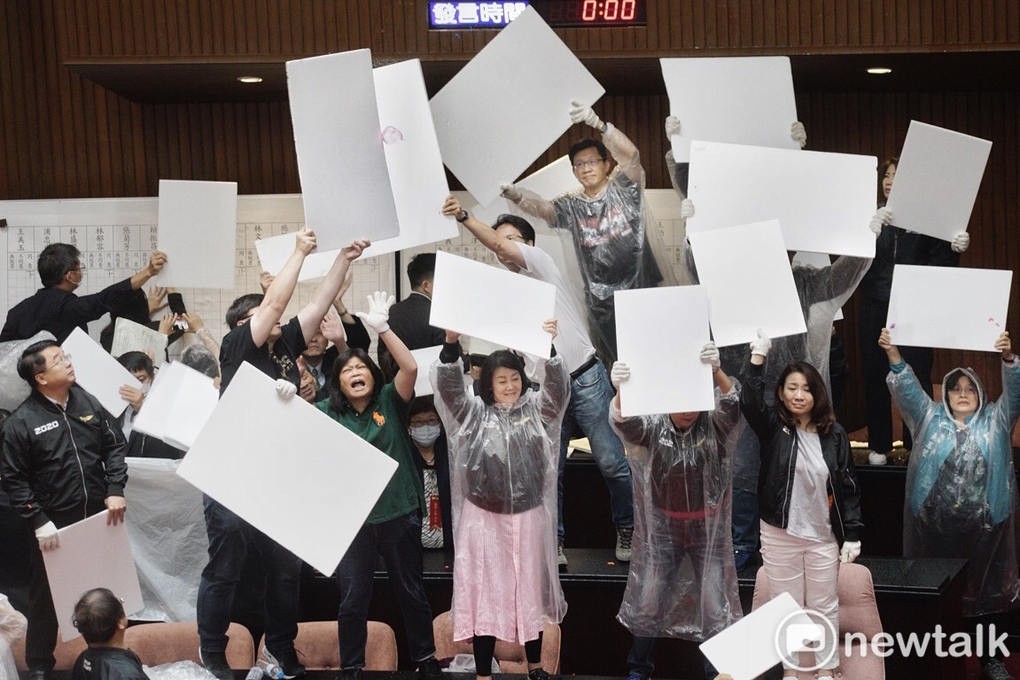 國民黨立委在監察院人事案開票時丟擲大量水球,民進黨立委則高舉白色板子擋水球。 圖:張良一/攝 國民黨立委在監察院人事案開票時丟擲大量水球,民進黨立委則高舉白色板子擋水球。 圖:張良一/攝