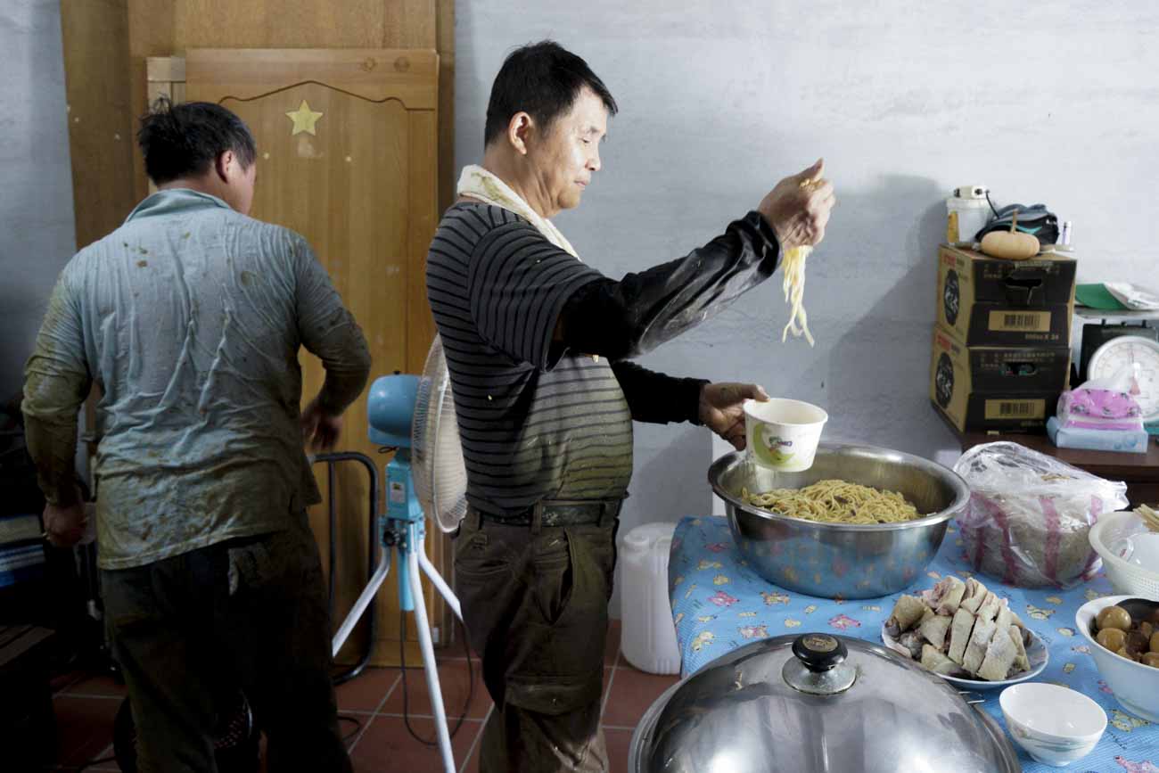 割稻割得滿身大汗,全身濕透的農友們享用田主準備的豐盛點心。 圖:張良一/攝 割稻割得滿身大汗,全身濕透的農友們享用田主準備的豐盛點心。 圖:張良一/攝