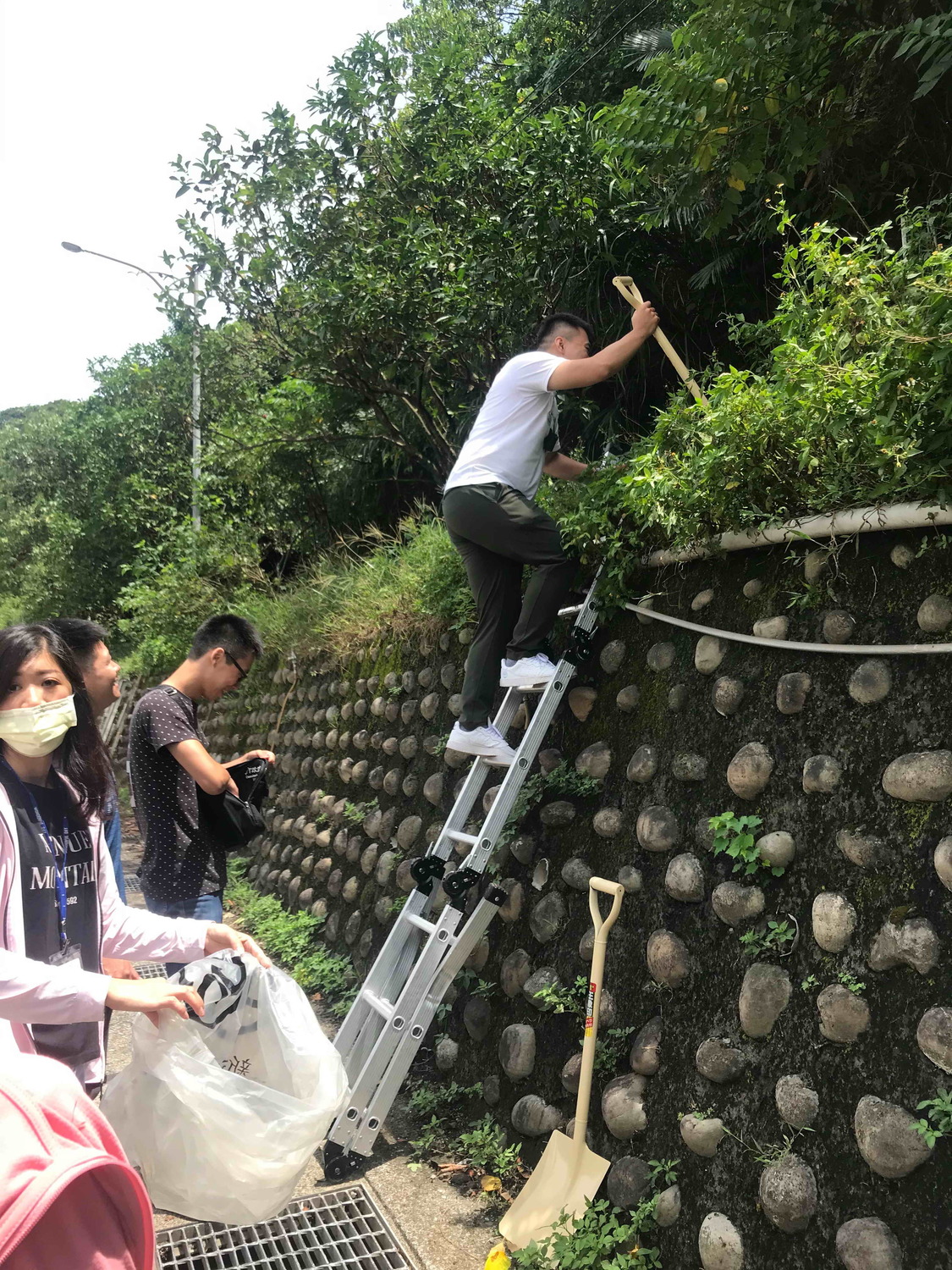 稽查員爬上邊坡蒐證。 圖:新北市環保局提供 稽查員爬上邊坡蒐證。 圖:新北市環保局提供