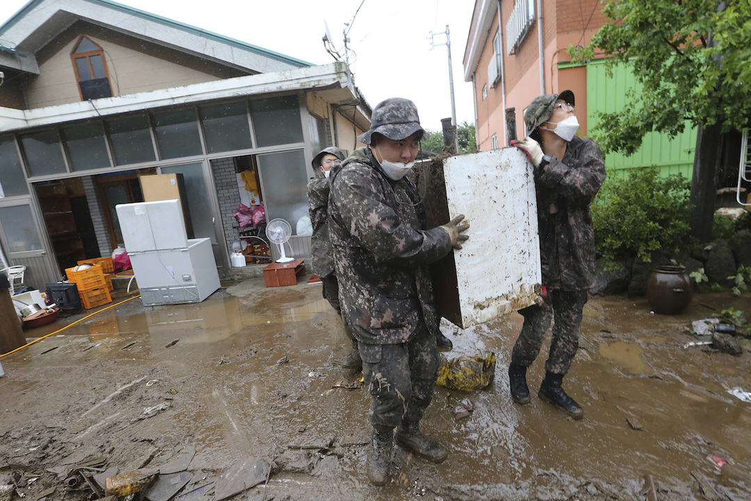 韓國秋原市遭受大雨洪水,陸軍士兵從受損房屋中運送殘骸。 圖:達志影像/美聯社 韓國秋原市遭受大雨洪水,陸軍士兵從受損房屋中運送殘骸。 圖:達志影像/美聯社