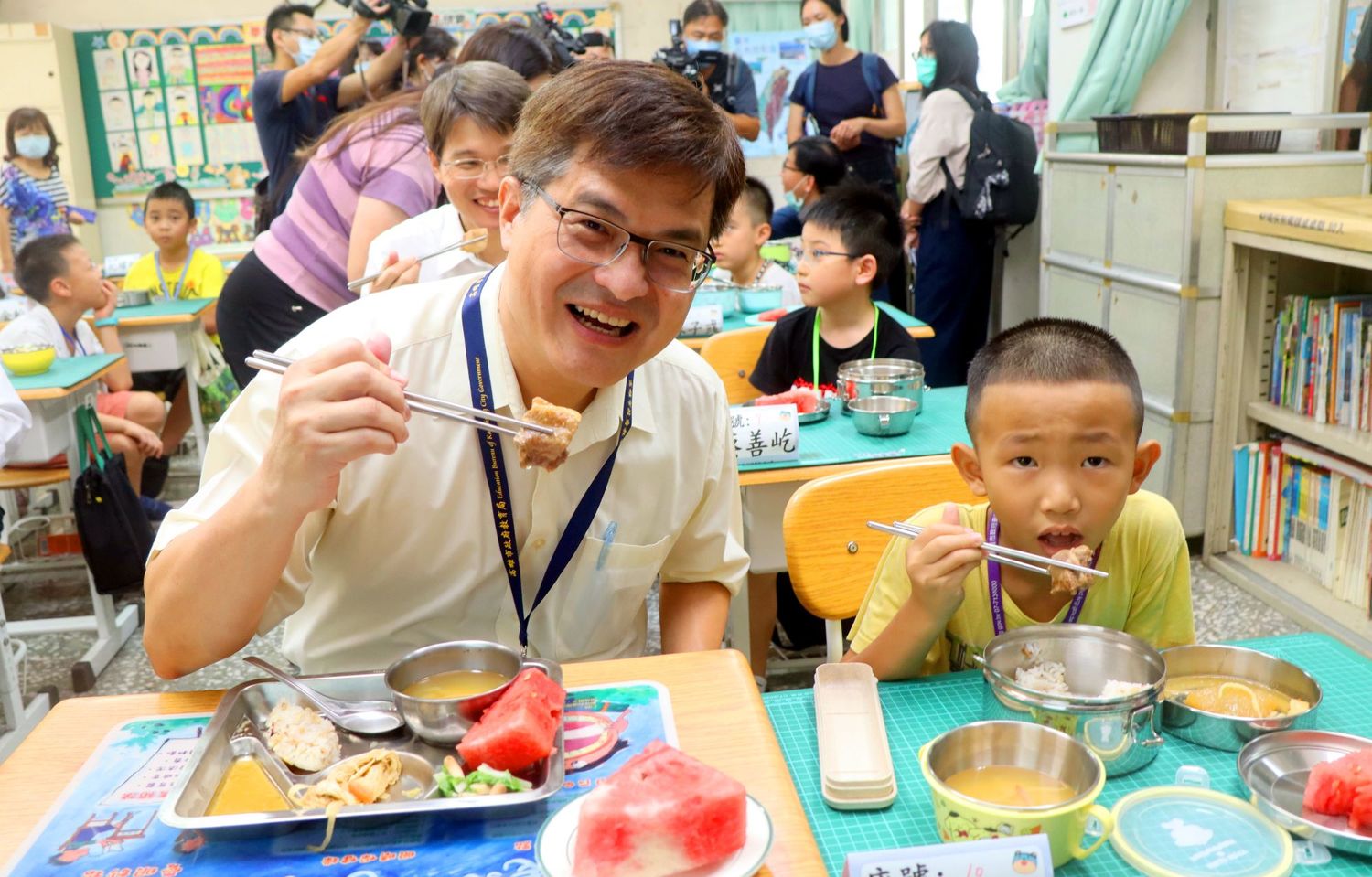 高市教育局長謝文斌(左)與學童共用營養午餐。 圖:高雄市政府/提供 高市教育局長謝文斌(左)與學童共用營養午餐。 圖:高雄市政府/提供