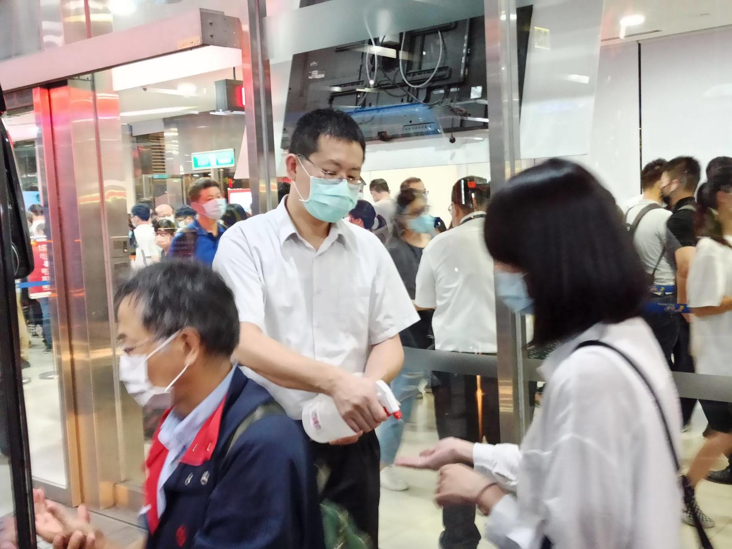 車站服務人員為乘客手部消毒。 圖:首都、臺北客運提供 車站服務人員為乘客手部消毒。 圖:首都、臺北客運提供