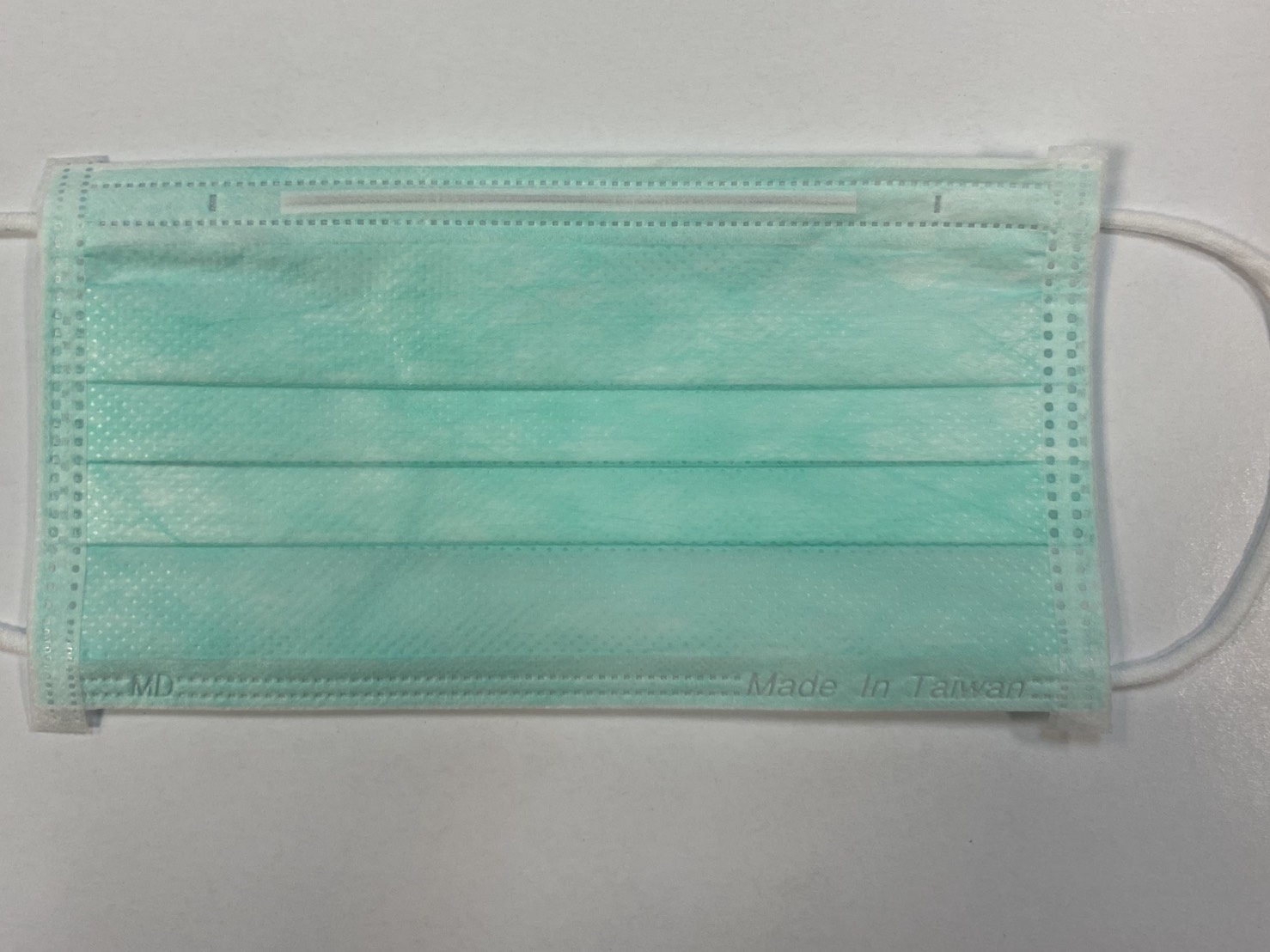 雙鋼印實名制口罩今(24)於實名制藥局上路,平面醫用口罩必須在邊緣1.5公分以內標示大於0.4公分的「MD」及「Made In Taiwan」字樣 圖:曾郡秋/攝 雙鋼印實名制口罩今(24)於實名制藥局上路,平面醫用口罩必須在邊緣1.5公分以內標示大於0.4公分的「MD」及「Made In Taiwan」字樣 圖:曾郡秋/攝