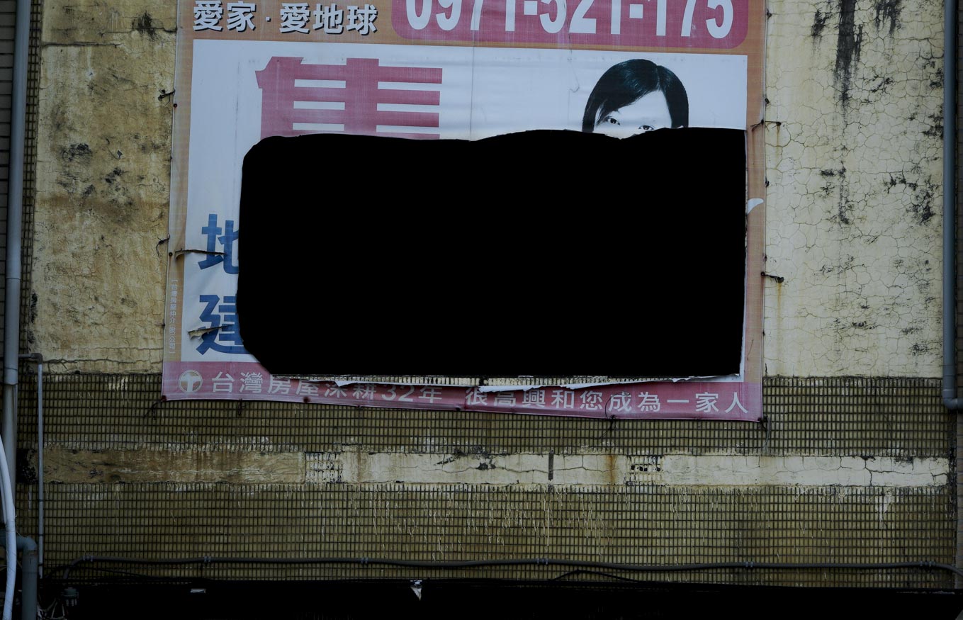 一棟位在桃園蘆竹區的台15線公路上的透天厝,一面房屋買賣的帆布廣告招牌被割了一大洞。 圖:張良一/攝 一棟位在桃園蘆竹區的台15線公路上的透天厝,一面房屋買賣的帆布廣告招牌被割了一大洞。 圖:張良一/攝