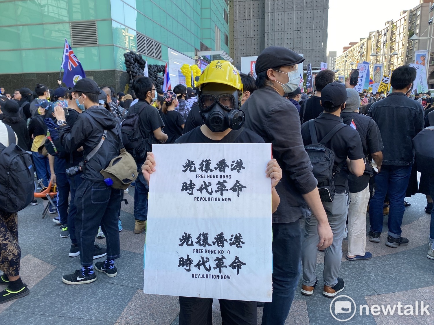 遊行民眾打扮成港人抗爭模樣,高舉「光復香港,時代革命」標語。 圖:周煊惠/攝 遊行民眾打扮成港人抗爭模樣,高舉「光復香港,時代革命」標語。 圖:周煊惠/攝