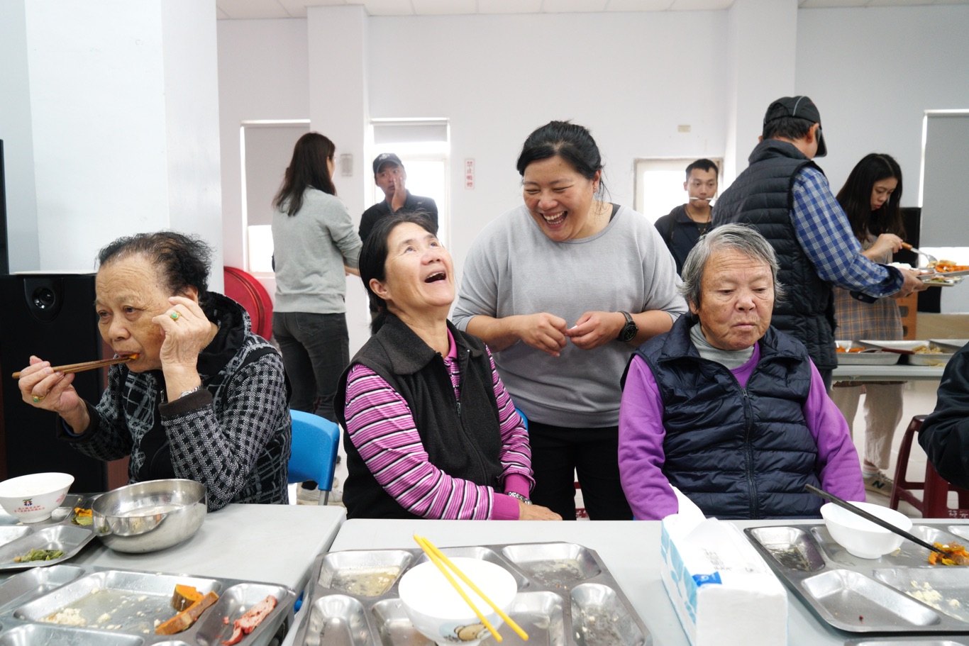 東莒社區發展協會舉辦的老人共餐活動,在「關島」期間如常進行,為老人家準備餐食的小葵(右二)和老人家們愉快聊天。 圖:張良一/攝 東莒社區發展協會舉辦的老人共餐活動,在「關島」期間如常進行,為老人家準備餐食的小葵(右二)和老人家們愉快聊天。 圖:張良一/攝