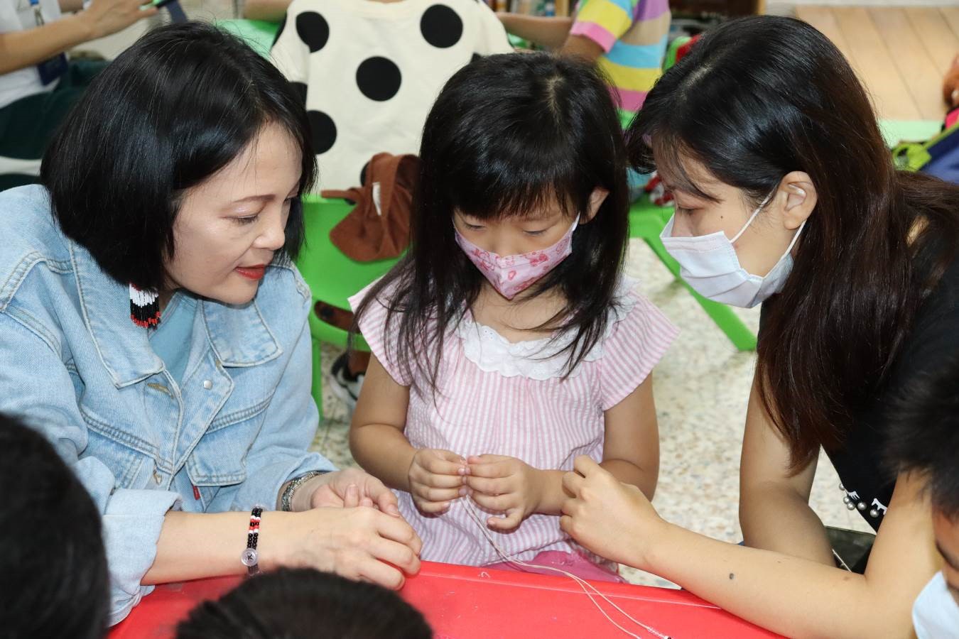 原民局長羅美菁(左)到場與小朋友們一起製作原住民族串珠手鍊,並與現場小朋友們一起互動 圖:新北市原民局提供 原民局長羅美菁(左)到場與小朋友們一起製作原住民族串珠手鍊,並與現場小朋友們一起互動 圖:新北市原民局提供